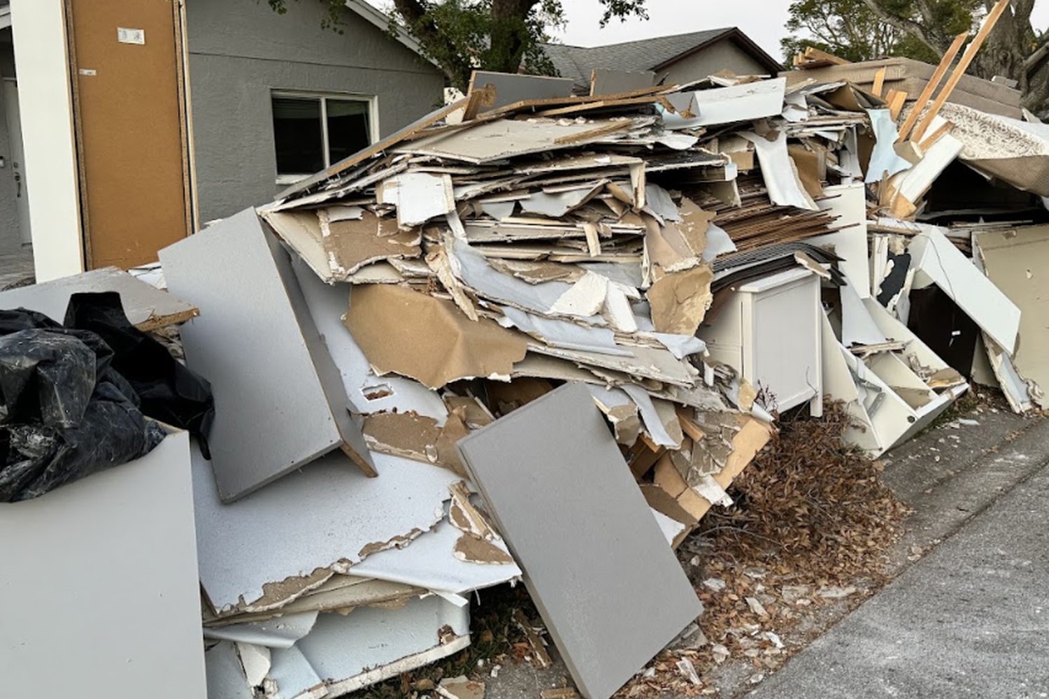Construction debris and drywall piled at the curb of a St. Petersburg home