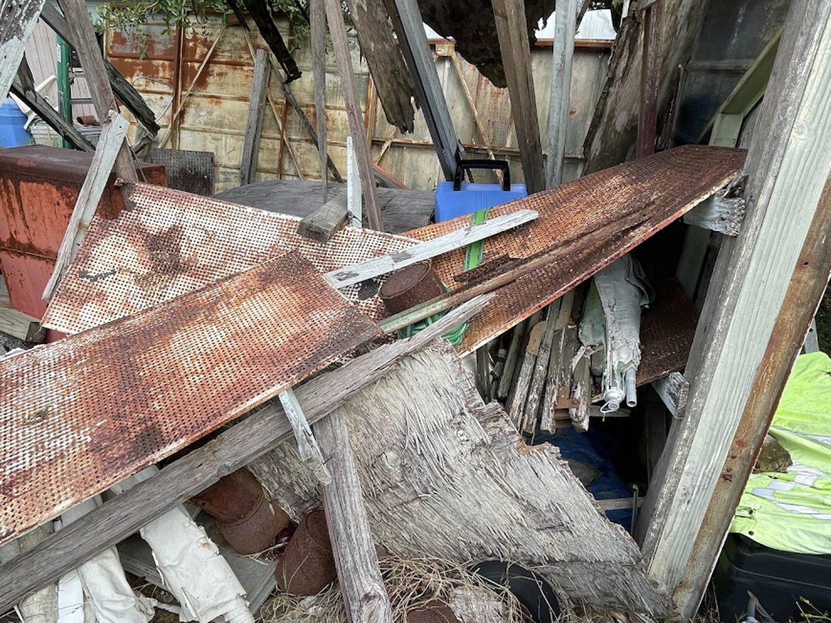 Collapsed rusted shed full of debris
